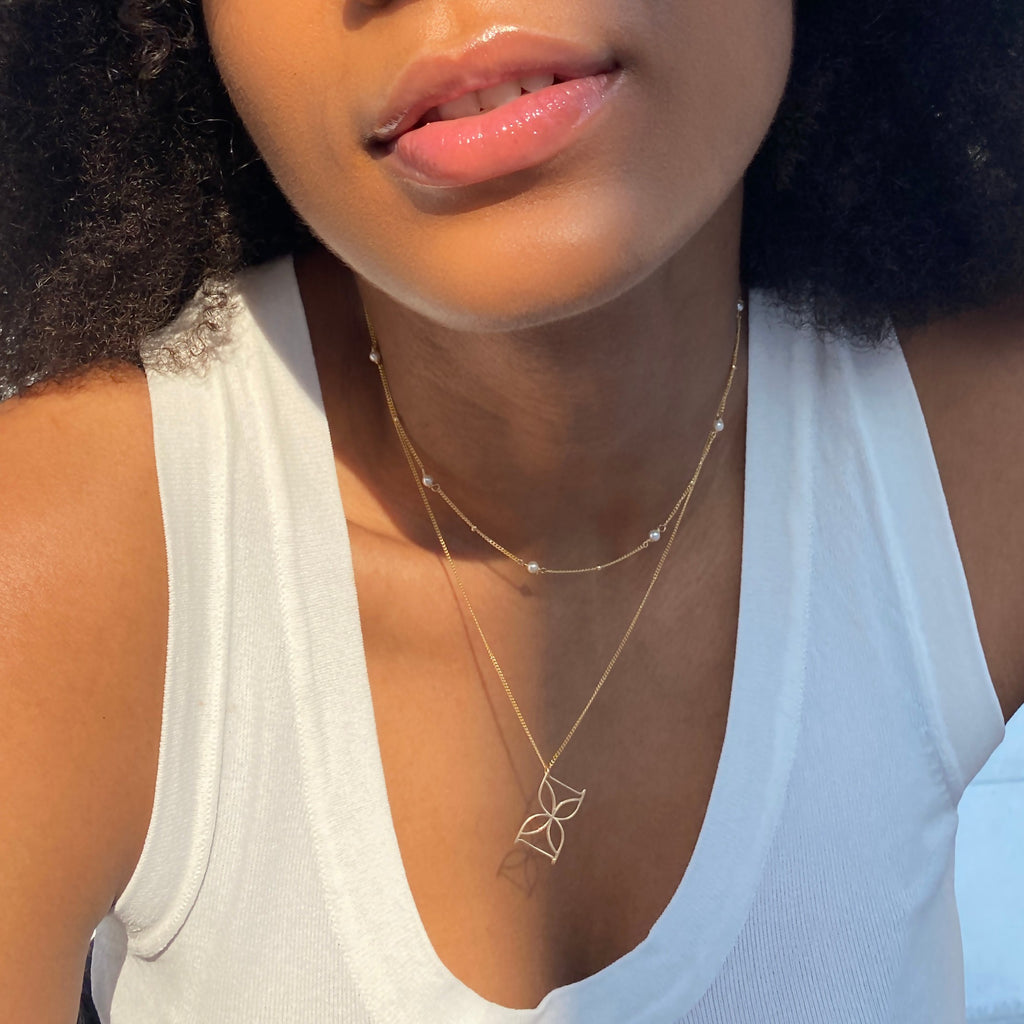 Desideri design signature logo charm pendant and satellite pearls necklace.